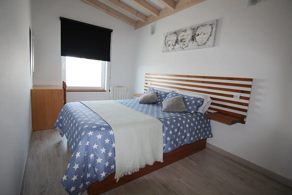 Dormitorio de un bungalow con ropa de cama azul