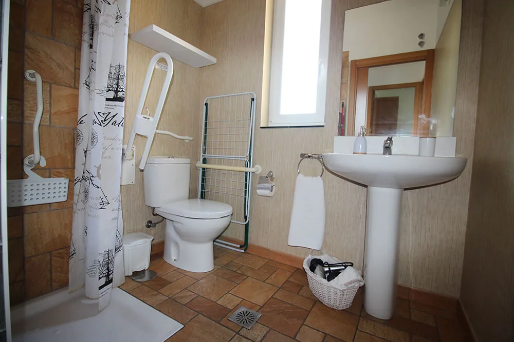 Baño accesible con barras de apoyo en un bungalow