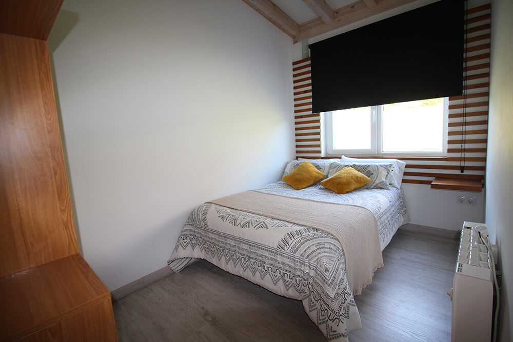Dormitorio de un bungalow con cama de matrimonio