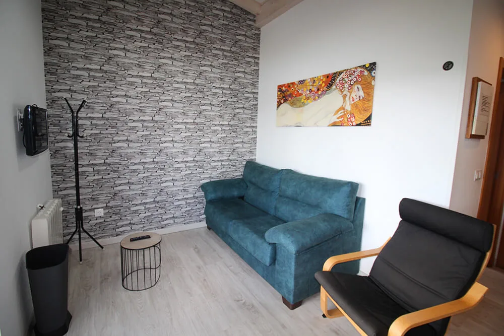 Salón de un bungalow con sofá y suelo de parquet