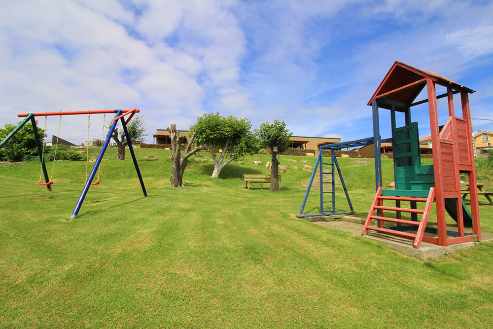 Children's play area with swings at Elma resort
